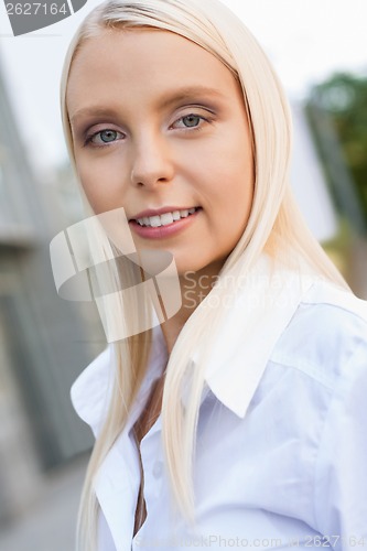 Image of attractive young successful smiling business woman standing outdoor 