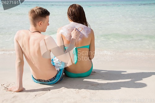 Image of Man drawing a heart on his girlfriends back