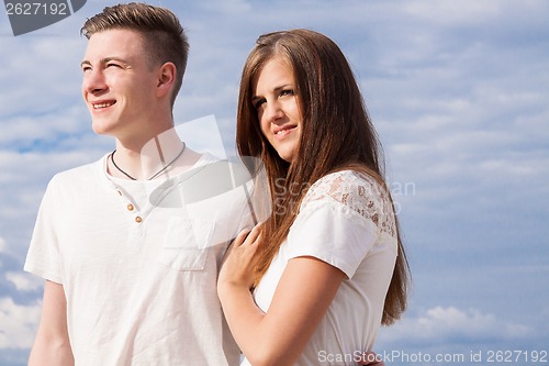 Image of romantic young couple sitting on the beach in summer