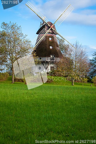 Image of Traditional wooden windmill in a lush garden