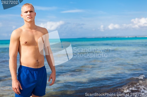 Image of attractive young athletic man on the beach