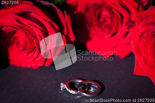 Image of Engagement ring with a bunch of red roses