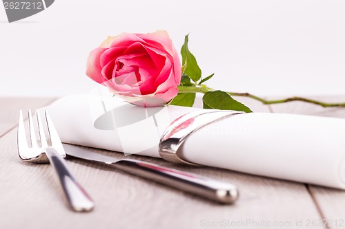 Image of Table setting with a single pink rose