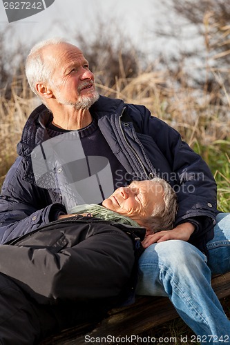 Image of happy senior couple relaxing together in the sunshine