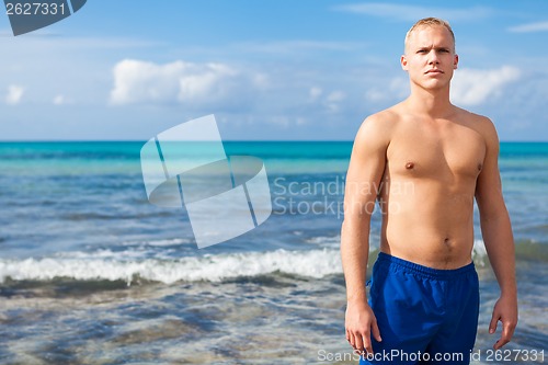 Image of attractive young athletic man on the beach