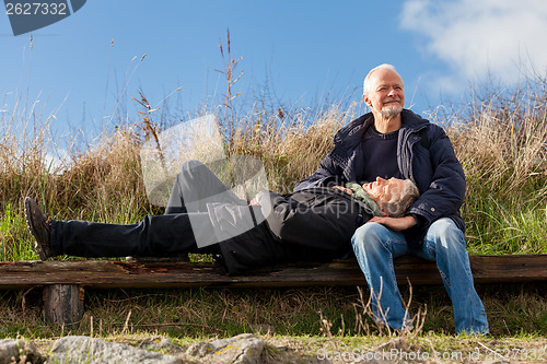 Image of happy senior couple relaxing together in the sunshine