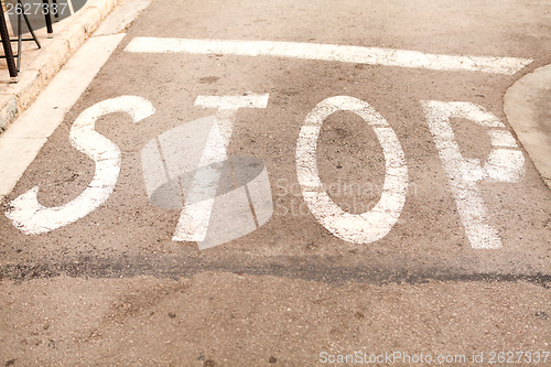 Image of stop painted on asphalt outdoor 