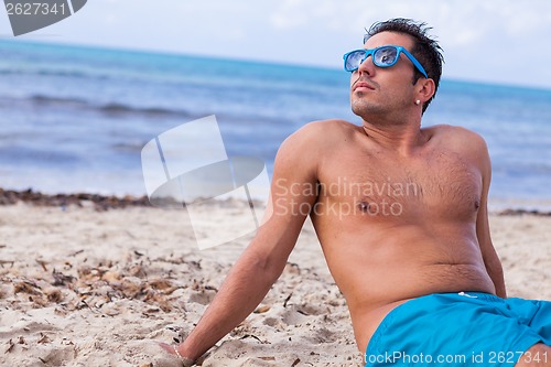 Image of attractive young athletic man on the beach