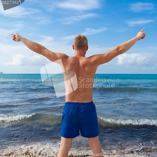 Image of attractive young athletic man on the beach