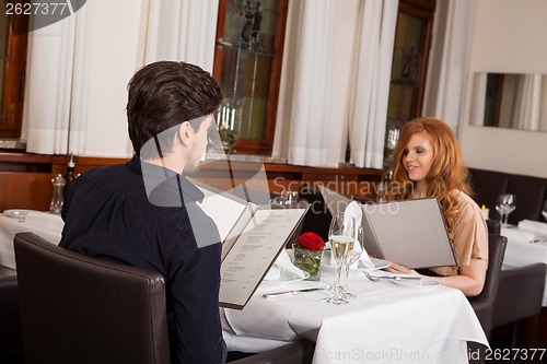 Image of Waiter serving a couple in a restaurant