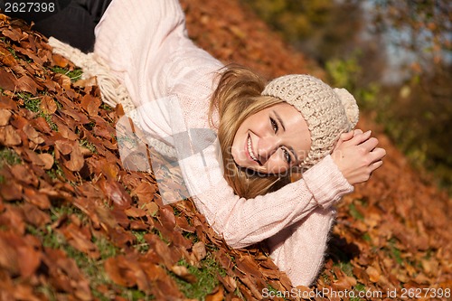 Image of young smiling woman with hat and scarf outdoor in autumn