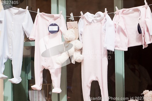 Image of baby clothing and teddy bear in window
