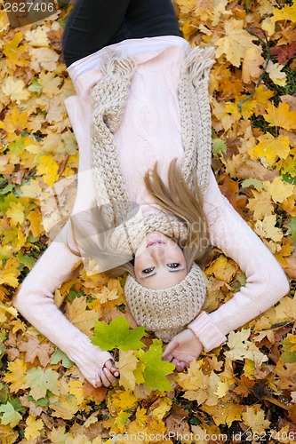 Image of attractive young woman relaxing in atumn park outdoor