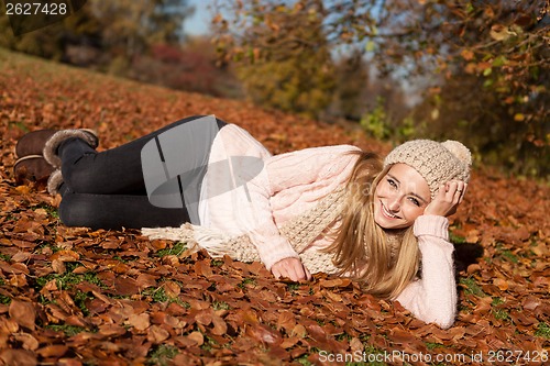 Image of young smiling woman with hat and scarf outdoor in autumn