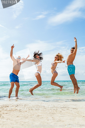 Image of young happy friends havin fun on the beach