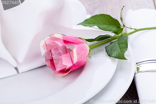 Image of Table setting with a single pink rose