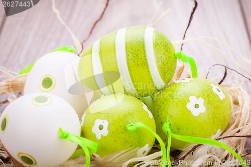 Image of Colourful green Easter eggs in straw