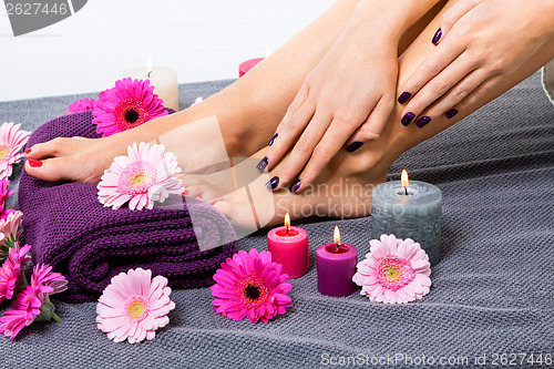 Image of Bare feet of a woman surrounded by flowers