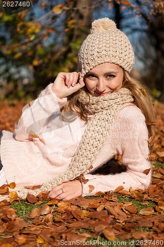 Image of young smiling woman with hat and scarf outdoor in autumn