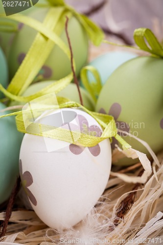 Image of Colourful green Easter eggs in straw