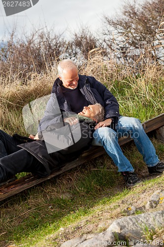 Image of happy senior couple relaxing together in the sunshine