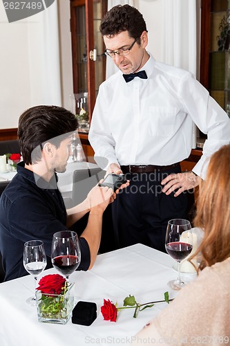 Image of young smiling couple at the restaurant 