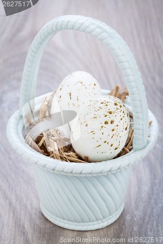 Image of Three natural blue Easter eggs in a basket