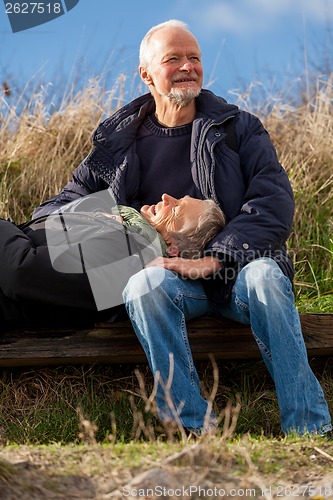 Image of happy senior couple relaxing together in the sunshine