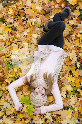 Image of attractive young woman relaxing in atumn park outdoor
