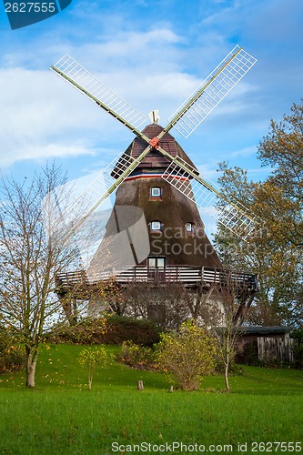 Image of Traditional wooden windmill in a lush garden