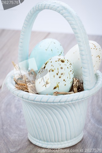 Image of Three natural blue Easter eggs in a basket