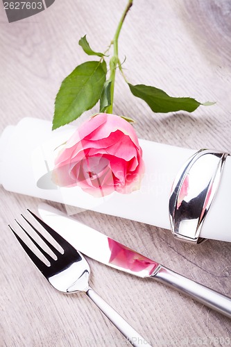 Image of Table setting with a single pink rose