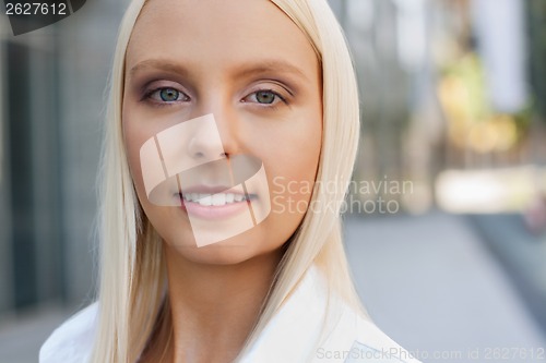 Image of attractive young successful smiling business woman standing outdoor 