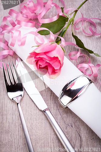 Image of Table setting with a single pink rose