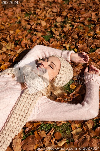 Image of young smiling woman with hat and scarf outdoor in autumn