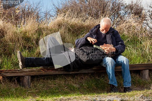 Image of happy senior couple relaxing together in the sunshine