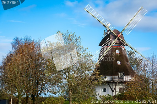 Image of Traditional wooden windmill in a lush garden