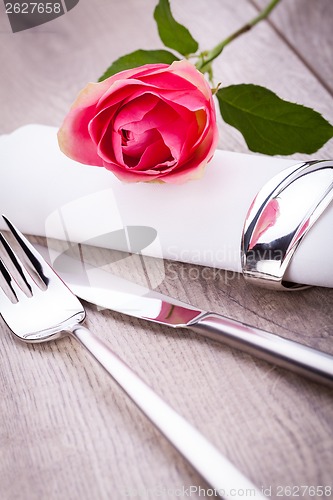 Image of Table setting with a single pink rose