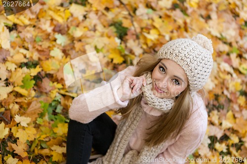 Image of attractive young woman relaxing in atumn park outdoor