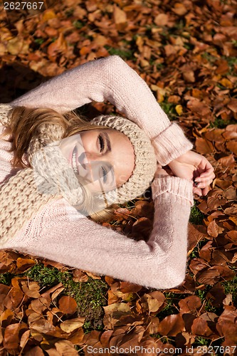 Image of young smiling woman with hat and scarf outdoor in autumn