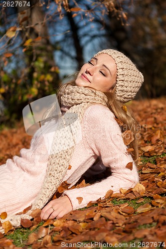 Image of young smiling woman with hat and scarf outdoor in autumn