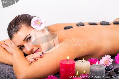 Image of young attractive woman hot stone massage wellness