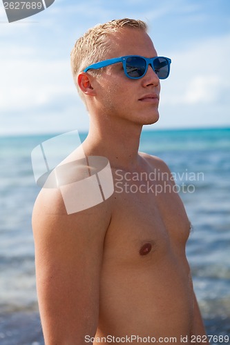 Image of attractive young athletic man on the beach