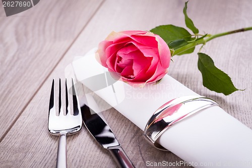 Image of Table setting with a single pink rose