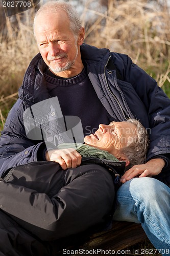 Image of happy senior couple relaxing together in the sunshine