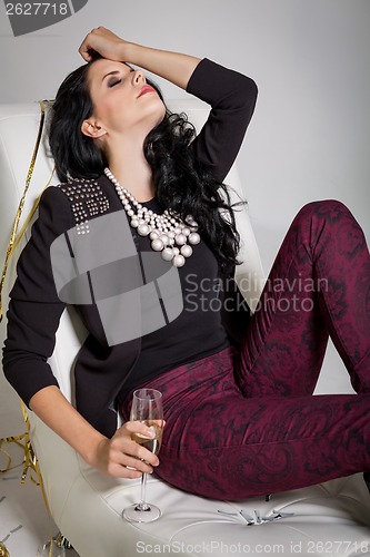 Image of Seductive brunette holding a glass of champagne