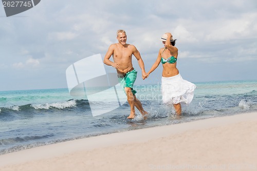 Image of young happy couple walking on beach sunset holiday