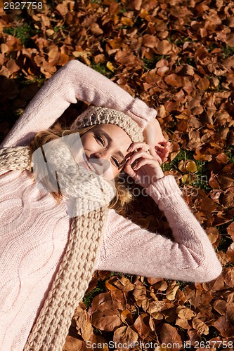 Image of young smiling woman with hat and scarf outdoor in autumn