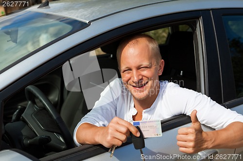 Image of Excited driver holding the keys of his new car