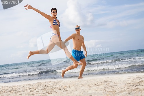 Image of young happy couple walking on beach sunset holiday